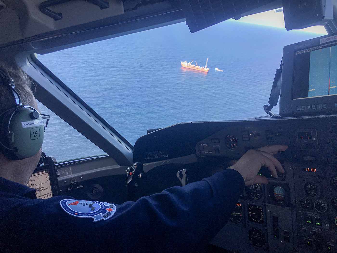 On aperçoit un navire de la fenêtre du pilote d’un avion de surveillance du PNSA pendant une patrouille des plans d’eaux pour détecter la présence de pollution.